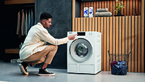 Image of a man using a Miele washing machine